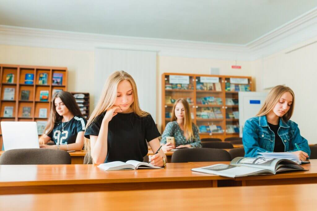 A group of secondary school students engaged in learning at their desks in a classroom setting.