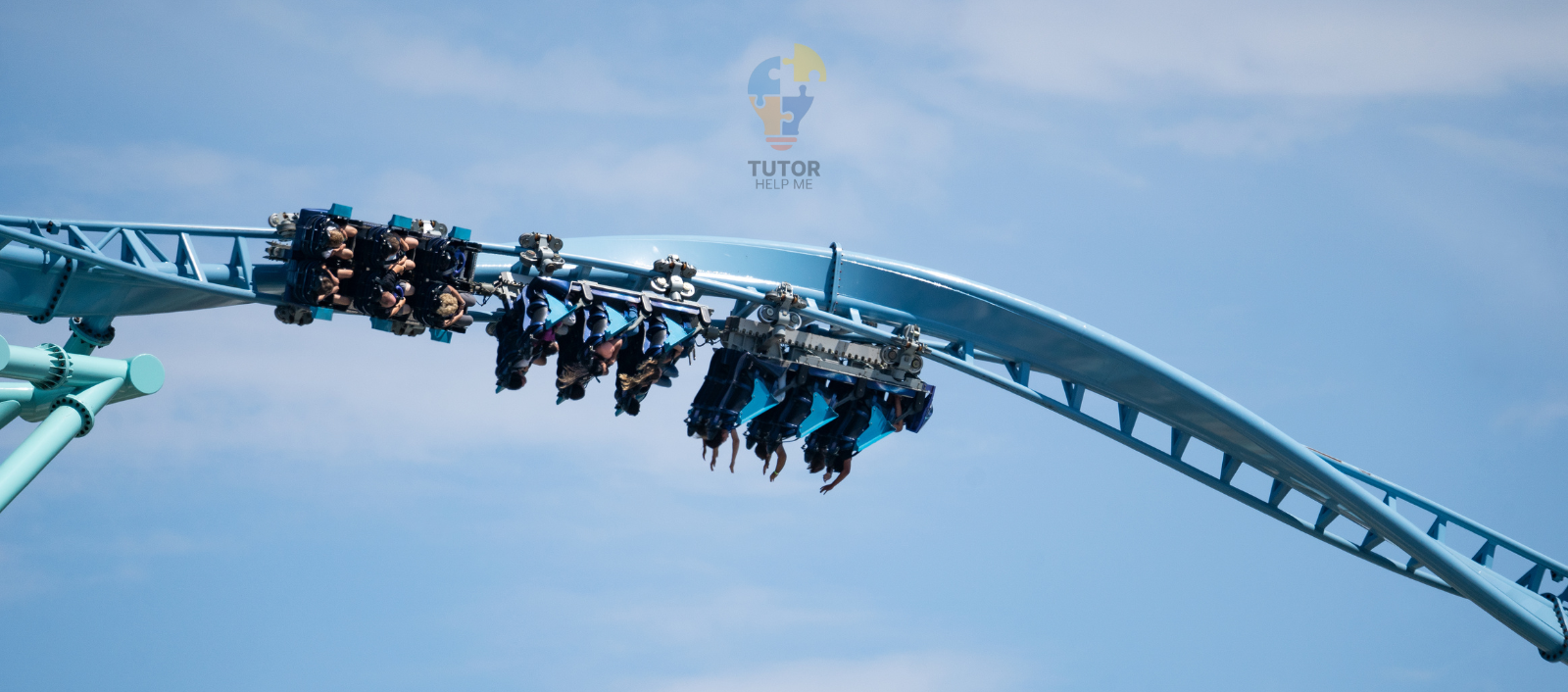 A blue roller coaster loop with excited riders hanging upside down against a clear sky, showcasing thrill and motion.