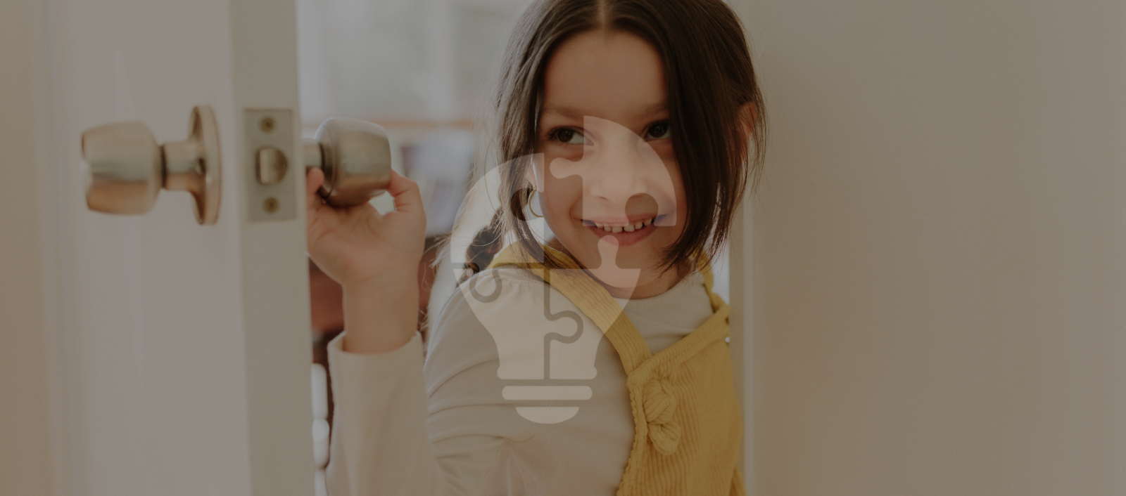 A child wearing a yellow vest holds a doorknob, ready to step through a partially open door into a bright room.