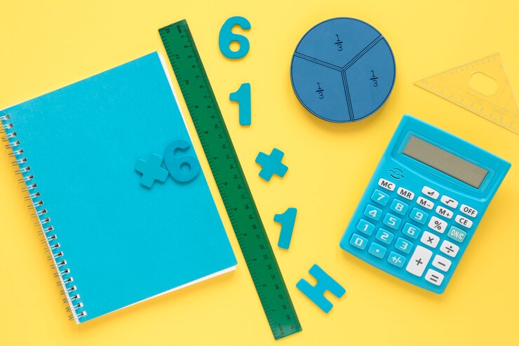 A turquoise notebook, ruler, calculator, and geometric shapes on a yellow background, featuring math expressions and numbers.