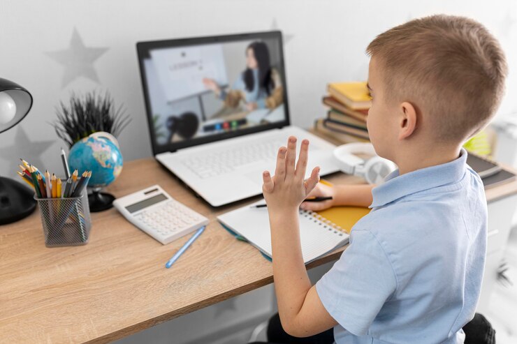 A child sits at a desk with a laptop, engaged in an online learning session, surrounded by stationery and a globe.