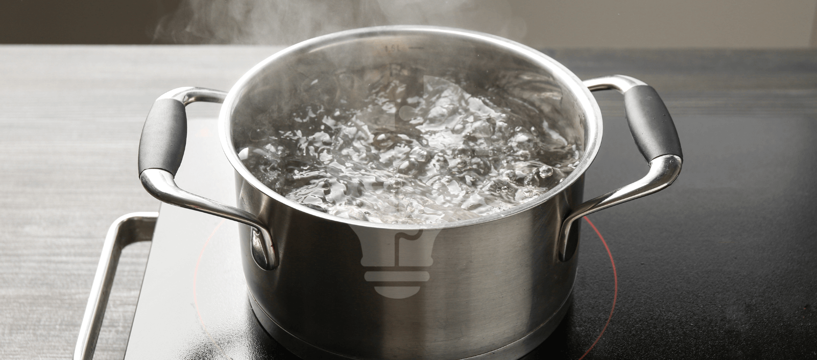 A metal pot with black handles is filled with bubbling, steaming water on a black stovetop, conveying a sense of heat and cooking activity.