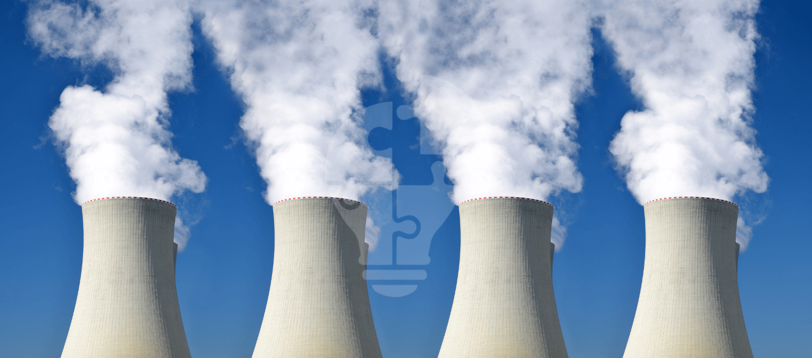 Four cooling towers emitting steam against a clear blue sky, symbolizing industrial power generation and environmental concerns.